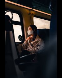 Midsection of man holding camera while sitting in car