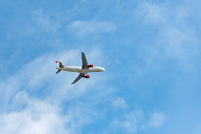 Commercial passenger jet airplane in mid flight on blue sky