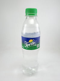 Close-up of empty glass bottle against white background