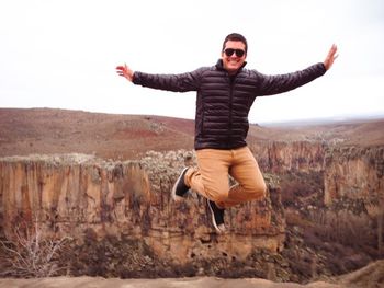 Portrait of young man with arms outstretched