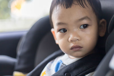 Portrait of cute baby boy in car