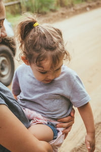 Midsection of mother holding daughter while standing outdoors