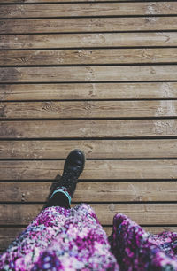 Low section of woman standing on boardwalk