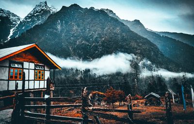 House on snowcapped mountain against sky