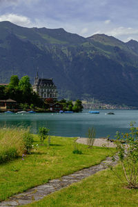 Scenic view of river by buildings against sky