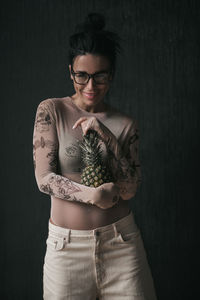 Beautiful young woman standing against black background