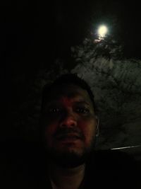 Portrait of man against illuminated light at night