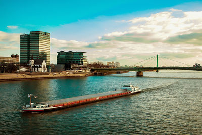 Bridge over river in city against sky