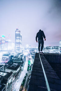 Rear view of man walking on cityscape