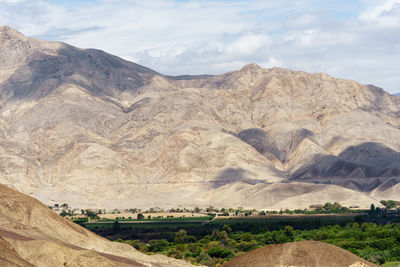 Scenic view of mountains against cloudy sky