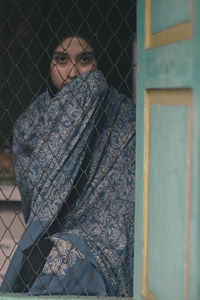 Portrait of woman looking through window