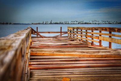 Wooden posts on beach against sky