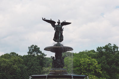 Low angle view of statue against fountain in park