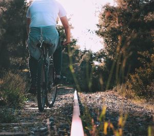 Rear view low section of man cycling on road