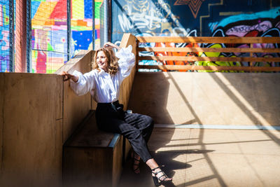 Full length of woman sitting on wall