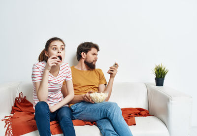 Woman sitting on sofa while eating food at home