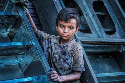 Portrait of boy standing on staircase