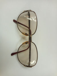 Close-up of eyeglasses on table against white background