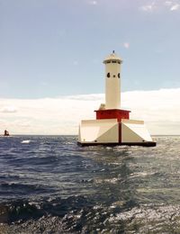 Lighthouse at lake michigan against sky