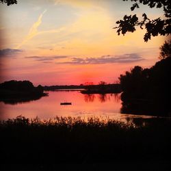Scenic view of lake against orange sky