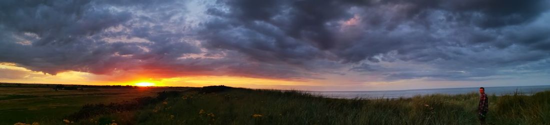 Panoramic view of field against sky during sunset