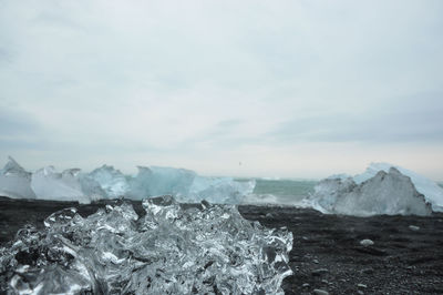 Black sand and crystal clear ice chunks at diamond beach in fellsfjara, jokulsarlon on iceland