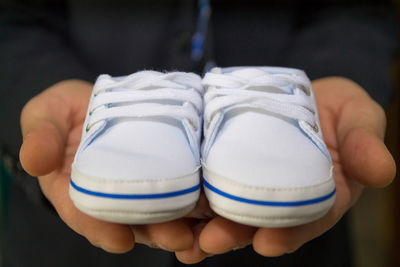 Low section of person holding white shoes