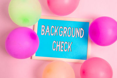 High angle view of multi colored balloons against pink background