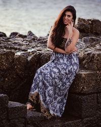 Portrait of young woman sitting on rock