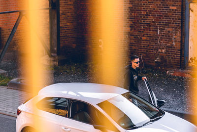 Woman standing by car in city