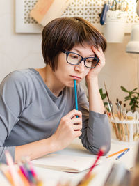 Woman with short hair cut is drawing in notebook. calming hobby, antistress leisure. artist at work.