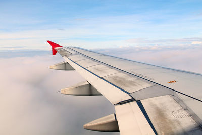 Airplane flying over clouds against sky