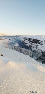 Scenic view of beach against clear sky during winter