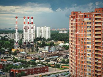 View of buildings in city against cloudy sky