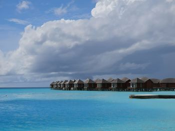 Scenic view of sea by buildings against sky