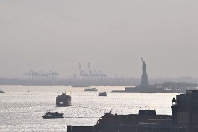 Silhouette statue of liberty in hudson river against sky