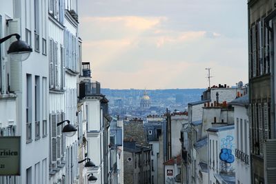 Buildings in city against cloudy sky