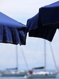 Cropped image of beach umbrellas against sky