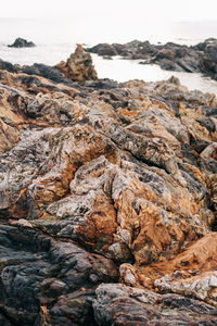 Rock formation on beach against sky