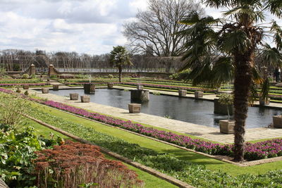 Scenic view of park by lake against sky