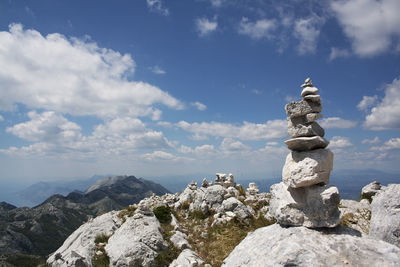 Statue by rock against sky