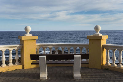 Railing by sea against sky