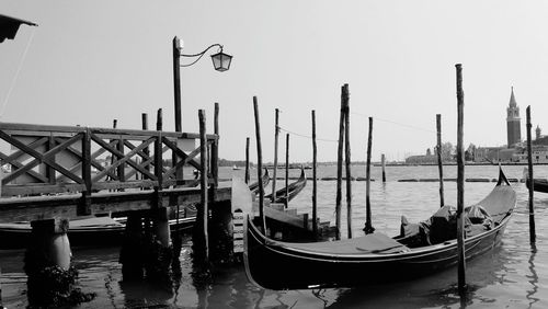 Boats moored in sea against clear sky