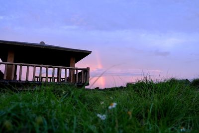 Built structure on field against sky during sunset