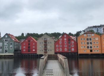 Houses by lake against sky