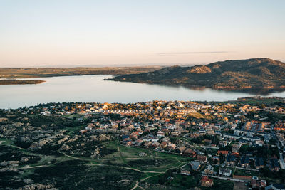 High angle view of townscape by river against sky