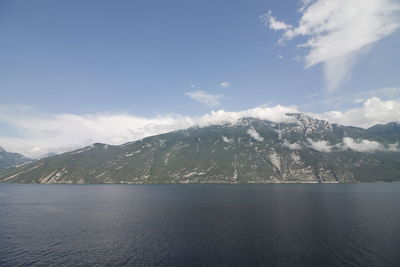 Scenic view of sea by mountains against sky