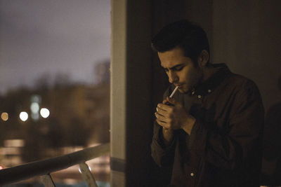 Man smoking cigarette at home