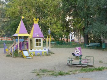 Empty chairs on beach against trees in park