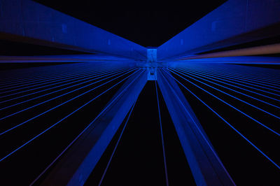 Low angle view of illuminated bridge against blue sky